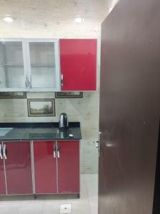 吉达الياسمين للشقق المفروشة的厨房配有红色橱柜和银色冰箱