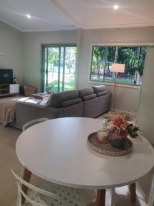 McMinns LagoonAdorable 2 bedroom unit, set in lush gardens的客厅配有白色桌子和沙发