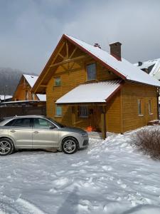 什切尔克Chata pod Skrzycznem LuLu的停在房子前面的雪地里的汽车