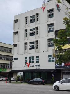 关丹Lovita Hotel Kuantan的前面有一辆汽车停放的白色建筑