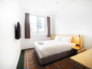 悉尼YHA Sydney Harbour的酒店客房配有一张床铺和一张桌子。