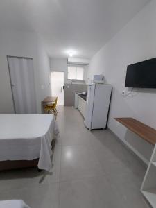 乌贝兰迪亚FLAT SABIÁ的白色的客房配有床和冰箱。