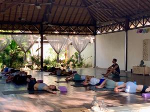 吉利特拉旺安瑜伽花园旅馆的一群人躺在地板上做瑜伽