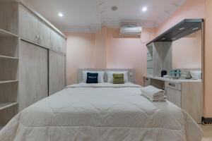 巴厘巴板Urbanview Palace Syariah Balikpapan by RedDoorz的卧室配有带枕头的大型白色床
