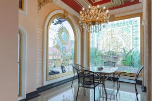 巴厘巴板Urbanview Palace Syariah Balikpapan by RedDoorz的一间带桌椅和吊灯的用餐室