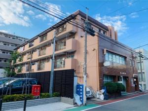 东京K&M Heights - Vacation STAY 32220v的街道上的建筑物,前面有停车位