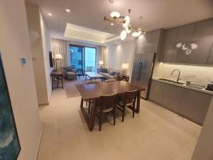 富查伊拉Address Beach Resort Residence Fujairah的厨房、带木桌的客厅和用餐室