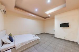 StalkudoUrbanview Hotel Garuda Sky Inn Balikpapan by RedDoorz的一间卧室配有一张床和一台平面电视