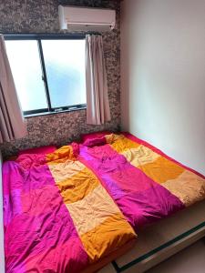 大阪智TOMO的一间卧室配有一张大床和色彩缤纷的被子