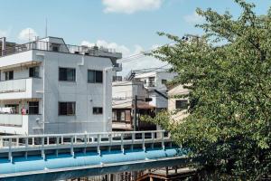 东京Bird Place log Tokyo #KS1的一座白色的建筑,有一座河上的桥梁