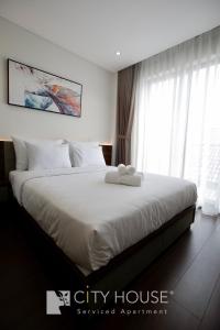 胡志明市Cityhouse Villea的一间卧室配有一张带白色床单的大床