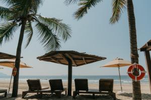 锡瓦塔塔内霍Las Palmas Luxury Villas的海滩上的一组椅子和遮阳伞