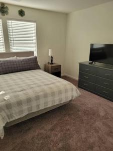 哥伦比亚SC 3755 New 2 bedroom Townhouse Ft Jackson & USC的一间卧室配有一张床、梳妆台和电视。