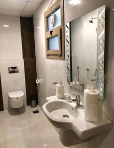 马斯喀特Weekdays Hotel的一间带水槽、卫生间和镜子的浴室