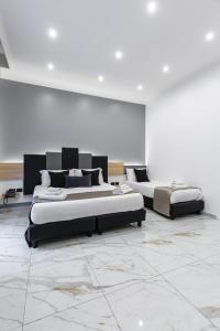 那不勒斯Hotel Sant'Angelo Palace的配有白色墙壁和大理石地板的客房内的两张床