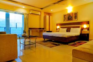 布巴内什瓦尔FabHotel Kanchan Plaza的一间卧室设有一张床和一间客厅。