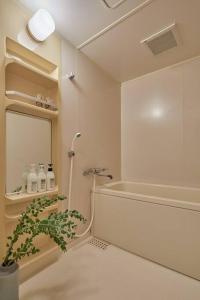 东京Holiday Places /SHIBUYA 5min by train (Sangenjaya)的带淋浴的浴室和镜子旁的植物