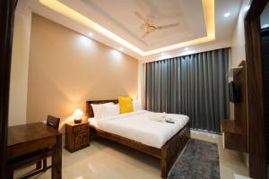 古尔冈Lime Tree Two BHK Service Apartment Golf Course Road Gurgaon的一间卧室设有一张床和一个带天花板的窗户。