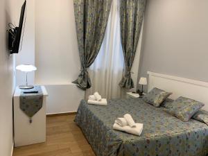 罗马贝拉维塔酒店的一间卧室,床上有白色的鞋