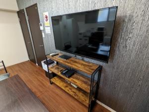 东京Amber Iidabashi的客厅配有壁挂式大屏幕平面电视