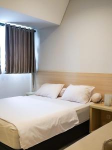 雅加达Mendjangan Residence的一间卧室配有一张带白色床单的床和一扇窗户。