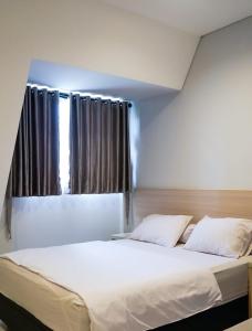 雅加达Mendjangan Residence的卧室配有一张大白色床和窗户