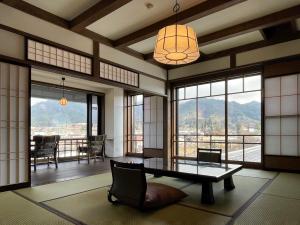 飞騨市亚苏三馆日式旅馆的客厅配有桌椅和窗户。