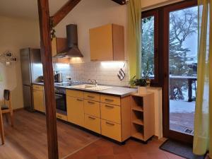 马格德堡Gästewohnung " Am Harsdorf "的厨房配有黄色橱柜、水槽和窗户。