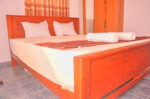 Gandara EastHimashi Sea View Homestay的一张带白色床单和白色枕头的大型木制床