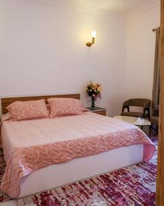 Zefta济夫塔礁酒店的一间卧室配有一张带粉红色棉被的大床