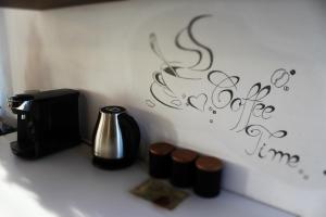 托普利察Casa Retro Toplița的一个带咖啡壶的柜台和一个带书写的墙壁