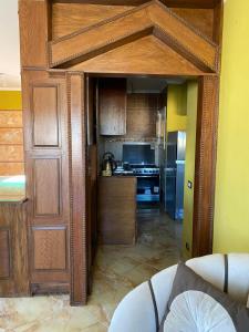 沙姆沙伊赫Al Crown的厨房设有一扇开放式门,通往带冰箱的厨房