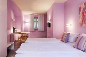 维尔茨堡Hotel Kunterbunt - by homekeepers的紫色墙壁客房的两张床