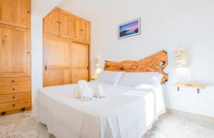 科尔萨诺Villa Tumari Private Pool的卧室配有白色的床和木制床头板