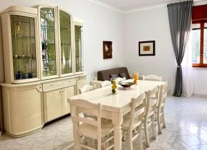 索伦托Sorrento's Carme family big appartament的一间配备有白色桌椅的用餐室
