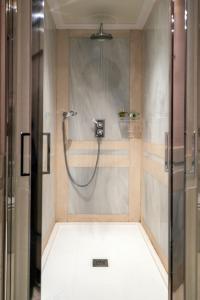 马德里Relais & Châteaux Hotel Orfila的带淋浴的浴室,带玻璃门
