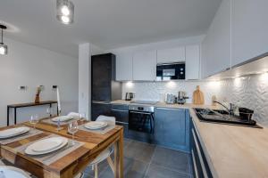 安锡Le Paradis - Beautiful T2 ideally located with garage的厨房配有木桌和蓝色橱柜。