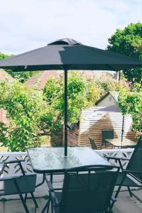 法尔茅斯The Palm House Falmouth - minutes from the beach!的庭院内桌椅和遮阳伞