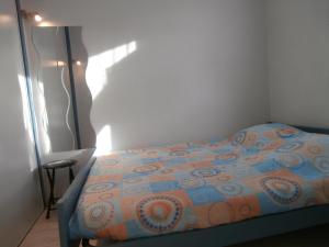 塞尼奥斯Appartement Seignosse, 2 pièces, 4 personnes - FR-1-239-460的一间卧室配有一张带橙色和蓝色棉被的床
