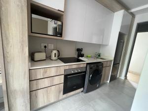 巴利托Zimbali Boulevard Suites 159的厨房配有洗衣机和水槽