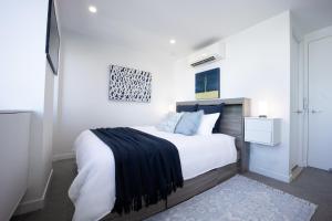布里斯班Spring Hill - beautiful apartment的一间卧室配有一张大床,床上铺有黑色毯子