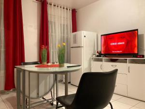 巴黎Studio calme et éclairé proche de Nation C的厨房配有桌子、电视和红色窗帘