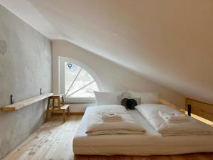 格门德蒂格斯Gmunder Premium Dachgeschoss-Apartments的配有大窗户的客房内的白色床
