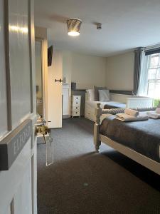 NewendenThe White Hart的一间卧室设有两张床和窗户。