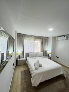 阿克拉Hilton Premium Suite, Labone的卧室配有带毛巾的大型白色床