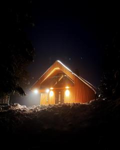VitanjeBrunarica Rogla的夜间亮着灯的谷仓