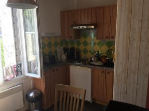 勒蒙多尔Appartement Mont-Dore, 3 pièces, 4 personnes - FR-1-415-61的一个带木制橱柜和窗户的小厨房