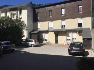 勒蒙多尔Appartement Mont-Dore, 3 pièces, 4 personnes - FR-1-415-61的两辆车停在停车场的大楼