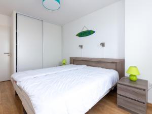 卡布勒通Appartement Capbreton, 3 pièces, 4 personnes - FR-1-239-387的卧室配有一张白色大床和绿灯