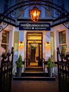 兰迪德诺The Wildings Hotel & Tudno's Restaurant的带有读取该酒店标志的酒店入口